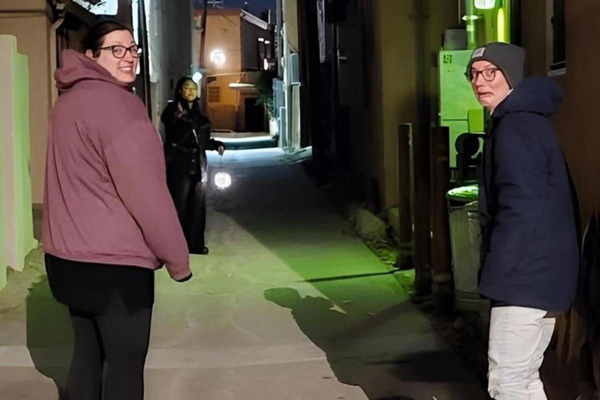two people are walking down a hallway